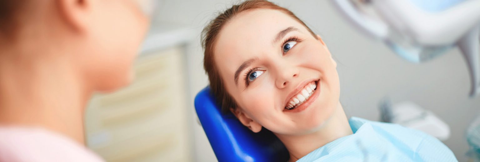 Happy patient sitting on a dental chair